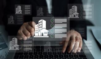 Pessoa usando computador com interface digital sobre imóveis e avaliações imobiliárias, representando o mercado imobiliário digital e tecnologia imobiliária.