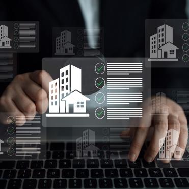 Pessoa usando computador com interface digital sobre imóveis e avaliações imobiliárias, representando o mercado imobiliário digital e tecnologia imobiliária.