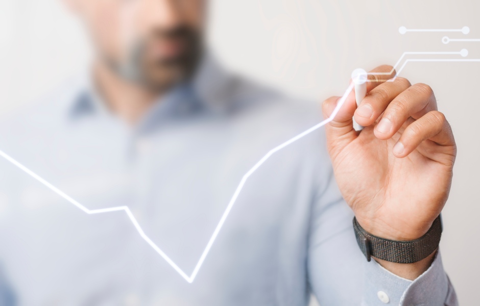 Executivo desenha um gráfico de crescimento em tela transparente com caneta digital, ilustrando resultados e tendências de forma futurista e dinâmica.