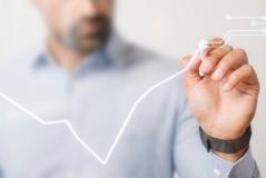 Executivo desenha um gráfico de crescimento em tela transparente com caneta digital, ilustrando resultados e tendências de forma futurista e dinâmica.
